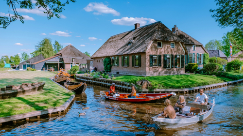 view of typical houses and tourist in boats of Giethoorn,The Netherlands.Venice of the North